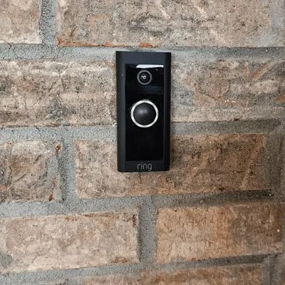 Ring video doorbell mounted flush on a brick entryway wall