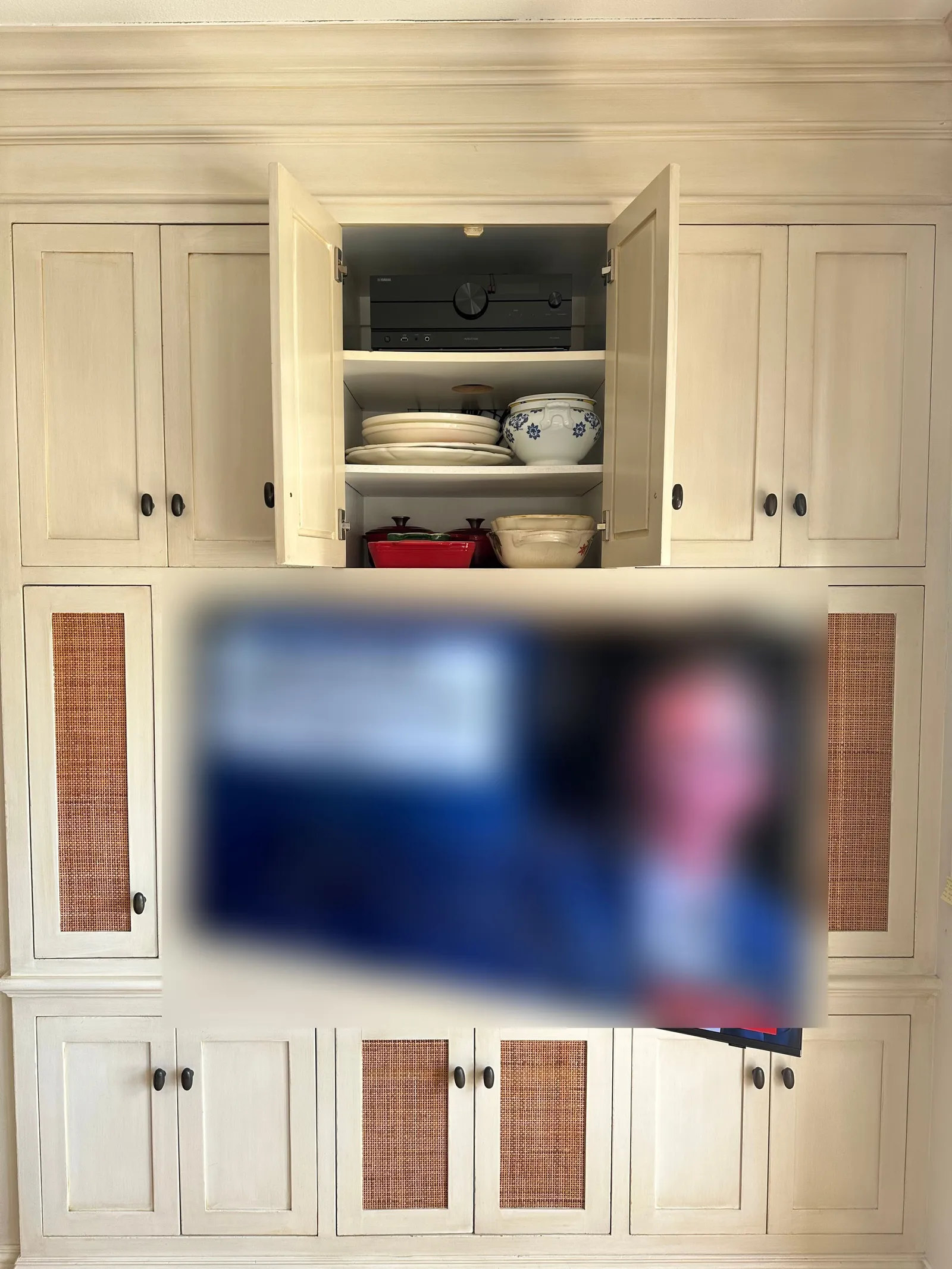 Television mounted into built-in cabinetry with the equipment concealed in a cabinet below
